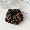 Detail view of leopard print scrunchie made of chiffon fabric with small woven label - Dark Coffee Leopard