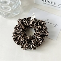 Dettaglio dell'elastico scrunchie maculato in tessuto setoso con trama plissettata di lusso - Leopardo Caffè Chiaro