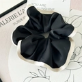 Detalle de un elegante coletero de seda negro y crema con pliegues suaves y brillo - Negro (Borde Ribeteado de Acetato)