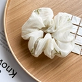 Dettaglio di scrunchie in organza bianca con ricamo di foglie verdi su vassoio di legno - Organza Bianco Ricamato con Foglie Verdi (Ricamo Organza)