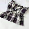 Gros plan d'un chouchou à carreaux violets avec étiquette faite main et bouton - Style Foulard Écossais Violet