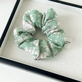 Dettaglio di scrunchie in chiffon floreale con motivo tie-dye verde e trama del tessuto - Stile di base / Tie-dye Verde