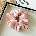 Close-up of a premium pink silk satin scrunchie with soft pleated texture on a display tray - Pink