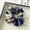 Detailed close-up of floral satin scrunchie with soft silk luster on a grey tray - Standard Scrunchie / Blue