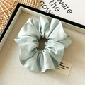 Macro shot of light blue tencel cotton scrunchie with soft pleated texture and silk sheen - Blue