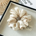 Detail view of a beige Tencel cotton scrunchie with high-quality fabric texture on a tray - Off White