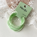 Primer plano de gomas de pelo verde menta de alta elasticidad sobre fondo de encaje - Verde