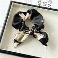 Macro detail of black floral satin scrunchie with bow decoration on a fashion magazine - Bow Scrunchie / Black