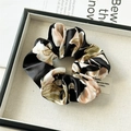 Makro-Detail von Satin-Haargummi mit Blumenmuster, Stofffalten und gewebtem Etikett - Standard Scrunchie / Schwarz
