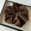 Macro shot of large dark brown satin scrunchie with soft silk texture in a tray - Large / Dark Coffee