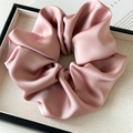 Detail of dusty rose satin scrunchie with pleated texture and soft glossy finish - Large / Pink