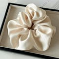 Detailed view of oversized champagne satin scrunchie with soft pleated texture and silk gloss - Large / Milky Yellow