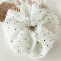 Primer plano de coletero de gasa blanca con lunares negros y elegantes pliegues - Blanco