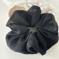 Detalle de un coletero grande de organza negra con lunares sobre encaje y mimbre - Negro