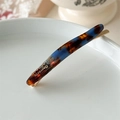 Dettaglio di un fermaglio per capelli in acetato tartarugato con clip in metallo oro - Caffè Blu