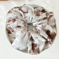 Detail of floral chiffon scrunchie with brown leaf patterns on cream fabric texture - Coffee Large Circle