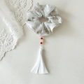 Détail du chouchou avec motif floral à l'encre, perles rouges et long gland blanc - Blanc