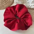 Detail shot of a premium large red satin scrunchie on a decorative lace background - Large / Red