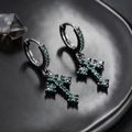 Detail van zwarte oorbel met kruishanger en groene zirkonia voor een moderne look - Zwart Groene Zirkonia