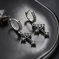 Detailopname van zilveren kruisringoorbellen met zwarte zirkoonstenen op een bord - Zilver Zwarte Zirkonia