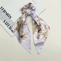 Detalle de un coletero de satén lavanda con flores y cintas largas colgantes - Cinta Peonía Morada