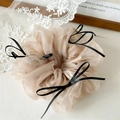 Détail du chouchou en organza champagne avec nœuds noirs pour coiffures de style ballet - Marron