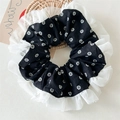 Detail eines schwarzen Vintage-Haargummis mit Blumenmuster und weißem Spitzenrand - Schwarz Floral