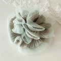 Detail of light green organza and grey pleated fabric scrunchie with layered ruffles - Green
