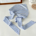 Dettaglio di un foulard a righe blu e bianche con lacci lunghi su un tavolo chic - Nastro Lungo a Righe Blu e Bianche