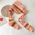Gedetailleerde close-up van gehaakte hoofddoek met kleurrijke strepen en een mesh textuur - Roze en Geel Gestreept