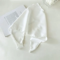 Close-up of a white fabric headscarf with elegant ruffled edges on a minimal background - White