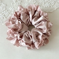 Detail of pink satin scrunchie with scalloped eyelet lace trim and silk texture - Pink