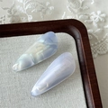 Detailed close-up of marble pattern acetate hair clips on linen fabric with lace - Blue