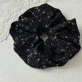 Detail eines übergroßen Blumen-Haargummis aus schwarzem Chiffon mit rosa Blütenmustern - Schwarz