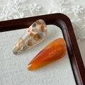Close-up of marble pattern and amber acetate hair clips in a rustic wooden tray - Caramel