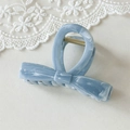 Detailansicht einer hellblauen Haarklammer mit Marmortextur und elegantem Schleifen-Design - Blaue Fliege