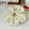 Detail van een grote geel-blauw gestreepte scrunchie met zachte stoftextuur en ruches - Enkellaagse Overlock