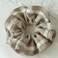 Detail von Mokka-braunem Falten-Haargummi mit weißer Spitze für elegante Pferdeschwänze - Khaki