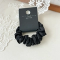 Dettaglio di un elastico in raso nero con etichetta nyunyu su fondo in pizzo elegante - Nero