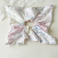 Close-up of pink floral and polka dot fabric scrunchie with brand label on a lace background - Pink Floral Square Scrunchie