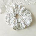 Detail of white cotton scrunchie with small floral patterns and fabric logo label - Light Color Small Flower Scrunchie
