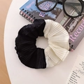 Detail of pleated two-tone scrunchie in black and white on a minimalist white desk - Black Patchwork Pleated
