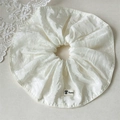 Coletero elegante de satén marfil con textura de seda y etiqueta de logo floral - Blanco