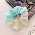 Detail of blue and beige pleated hair scrunchie in a stylish lifestyle setting - Green Patchwork Pleated