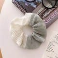 Detailed view of bicolor pleated chiffon scrunchie in beige and sage green on a desk - Gray Patchwork Pleated