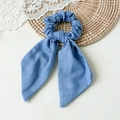 Close-up of light blue striped bow hair scrunchie with long ribbons on a woven mat - Solid Denim Blue