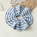 Dettaglio di un grande elastico scrunchie a righe blu e bianche su sfondo di pizzo rustico - Righe blu e bianche