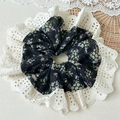 Detailed close-up of floral chiffon scrunchie with elegant white hollow lace trim - Floral Style / Black Lace Hollow