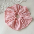 Detalle de un coletero grande de tela rosa con bordes rizados sobre fondo de encaje - Rosa Crema