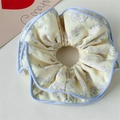 Florales Haargummi in Hellgelb mit lila Blumen und blauem Rand für Damenhaare - Cremiges Blumengelb